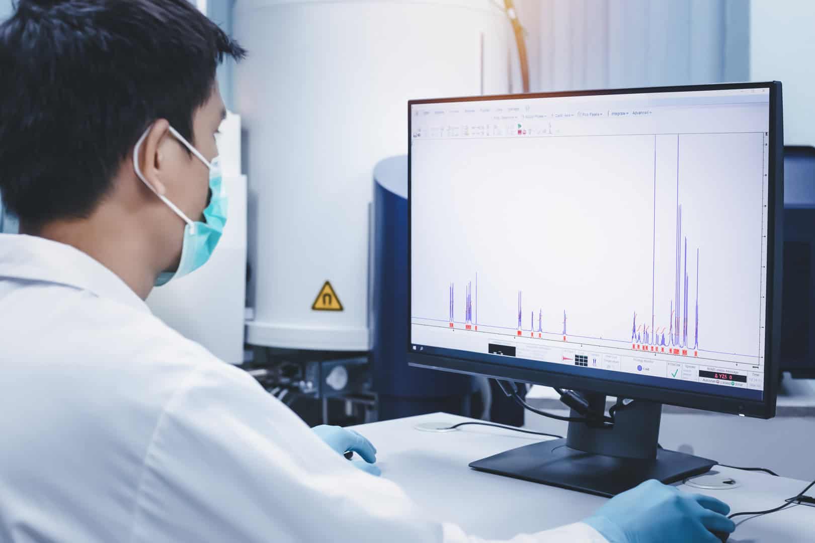 Azure Summit Technology | Scientist man checks the spectrum of sample analysis by nuclear magnetic resonance spectroscopy, NMR spectroscopy, as shown on a computer monitor in the laboratory.